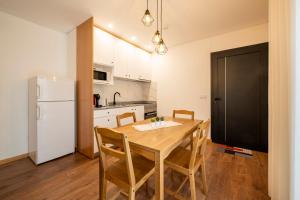 a kitchen with a wooden table and a white refrigerator at Terreiro da Serra in Rio Caldo
