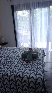 a person laying on a bed in front of a window at Résidence LE MÄYSA CORAIL in Sada