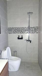 a bathroom with a toilet and a shower at Résidence LE MÄYSA CORAIL in Sada +13 photos