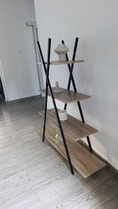 a wooden shelf sitting on a floor next to a wall at Résidence LE MÄYSA CORAIL in Sada