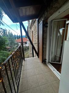 a balcony of a house with a glass door at Panorea house in Polydrossos +1 photo