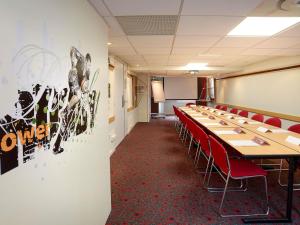 a conference room with a long table and red chairs at ibis Toulouse Centre in Toulouse