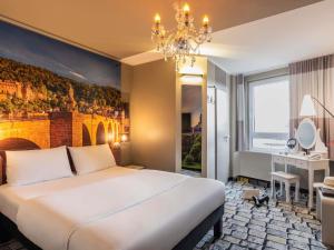 a bedroom with a large white bed and a chandelier at ibis Heidelberg Hauptbahnhof in Heidelberg +113 photos