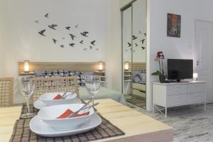 une salle à manger avec une table avec des verres et des oiseaux sur le mur dans l'établissement Standard Apartment by Hi5-Liszt Ferenc Square, à Budapest