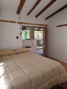 a bedroom with a large bed in a room with windows at Casa Hospedaje Saywa in Lamay +82 photos