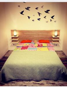 - une chambre avec un lit avec des oiseaux sur le mur dans l'établissement Standard Apartment by Hi5-Liszt Ferenc Square, à Budapest