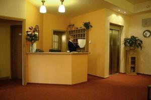 a lobby with a counter in a room with yellow walls at Hotel Barbarossa in Cheb