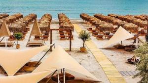a beach with chairs and umbrellas and the ocean at Ida Beach in Mamaia Sat/Năvodari