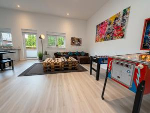 a living room with a table and a game room at Apartment Jonte im Dangaster Nest in Varel
