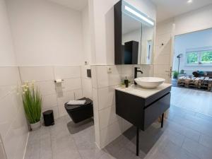 a white bathroom with a sink and a mirror at Apartment Jonte im Dangaster Nest in Varel