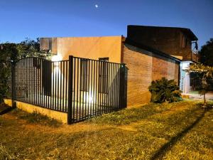 a fence in front of a house with a building at Monoambiente Privado in Luque