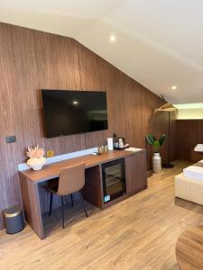 a room with a desk with a television on a wall at NOMA Rooms Murter in Murter