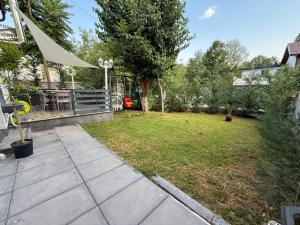 a backyard with a yard with a bench and a table at Villa ADUSHI Nashec in Prizren