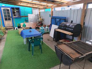 a backyard with a grill and a table and chairs at Cabaña Aldea 31 in Coihaique