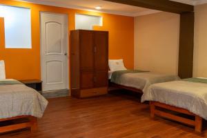 a room with two twin beds and a cabinet at Hotel Sol de Belén Cajamarca in Cajamarca +76 photos