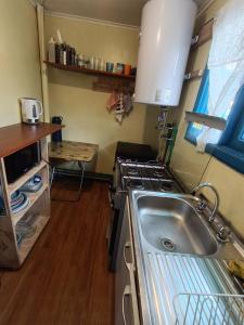 a kitchen with a sink and a stove at Cabaña Aldea 31 in Coihaique +11 photos