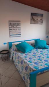 a bedroom with a bed with blue pillows at Casa Frida in Solanas