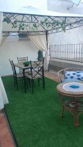 a room with a table and chairs on a green rug at Casa Frida in Solanas
