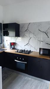 a kitchen with a counter with a stove top oven at Résidence LE MÄYSA CORAIL in Sada