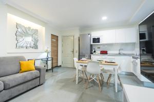 a kitchen and living room with a couch and a table at Suites Garden Apartamento 16 in Las Palmas de Gran Canaria