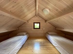 a room with two beds in a wooden cabin at Pięć Sosen in Wiele
