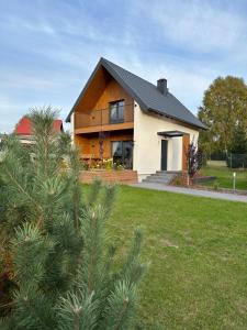 a house with a tree in front of it at Pięć Sosen in Wiele