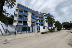 a white and blue building with a blue fence at Soberana del Mar by Colproperty Management in Santa Marta