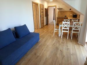 a living room with a couch and a table and chairs at u Harrego in Dębki +6 photos