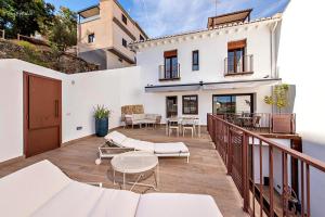 a balcony of a white house with furniture on it at La Cepa Apartamentos in Alhama de Granada
