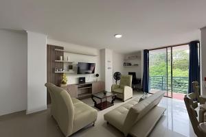 a living room with a couch and chairs and a tv at Soberana del Mar by Colproperty Management in Santa Marta