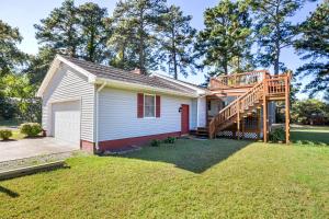a small white house with a wooden deck at Happy Pines in Chincoteague