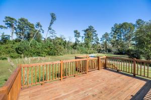 a large wooden deck with a grill on it at Happy Pines in Chincoteague