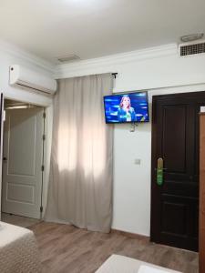 a room with a flat screen tv on a wall at Hostal Alcarayón Pilas in Pilas +30 photos