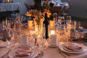 ein Tisch mit Tellern und Gläsern und eine Vase mit Blumen in der Unterkunft Hunter Lodge, a Bluebird by Lark in Hunter