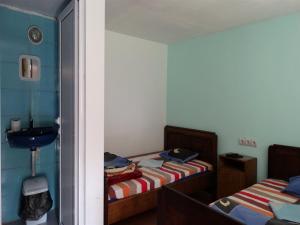 a small room with two beds and a sink at Roden Dom Holiday Home in Apriltsi