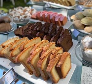 a table topped with different types of bread and pastries at Refugio MontSerrat in Urubici