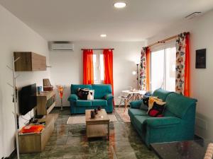 a living room with two blue couches and a tv at Alojamientos Harizan in Agaete