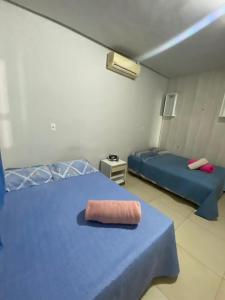 a bedroom with two beds and a pink towel on the bed at Casa com piscina in Imperatriz +22 photos