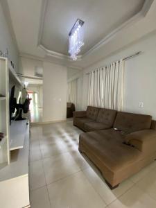 a living room with a couch and a chandelier at Casa com piscina in Imperatriz