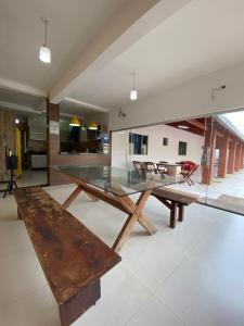 a dining room with a glass table and chairs at Casa com piscina in Imperatriz