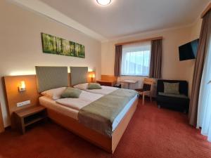 a hotel room with a bed and a chair at Panorama Hof Sereinig in Sankt Oswald +75 photos