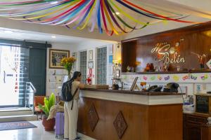 a woman standing at a bar in a restaurant at Hotel Sol de Belén Cajamarca in Cajamarca