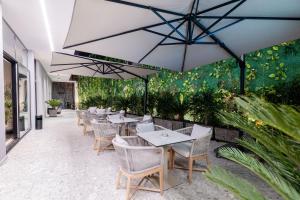 a row of tables and chairs with umbrellas on a patio at Boe Luxury Hotel in Sarandë