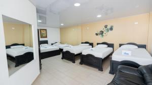 a room with four beds and a couch at Damar Hotel Collection Valledupar in Valledupar +28 photos