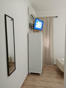 a television sitting on top of a mirror in a room at Hostal Alcarayón Pilas in Pilas