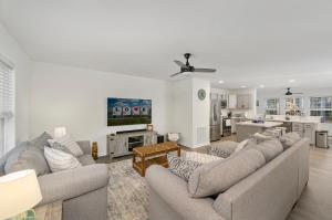 a living room with two couches and a kitchen at Hidden Gem in Greenbackville