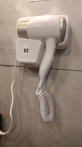 a white hair dryer hanging from a wall at Refúgio Aconchegante in São Sebastião