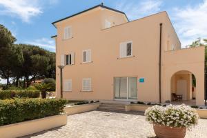 an exterior view of a large house with plants at Borgo al Mare in Marina di Bibbona