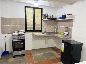 a small kitchen with a sink and a stove at Cabaña destino 11 in Mérida