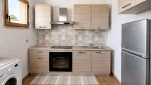 a kitchen with a sink and a refrigerator at Domo e Mare in Valledoria